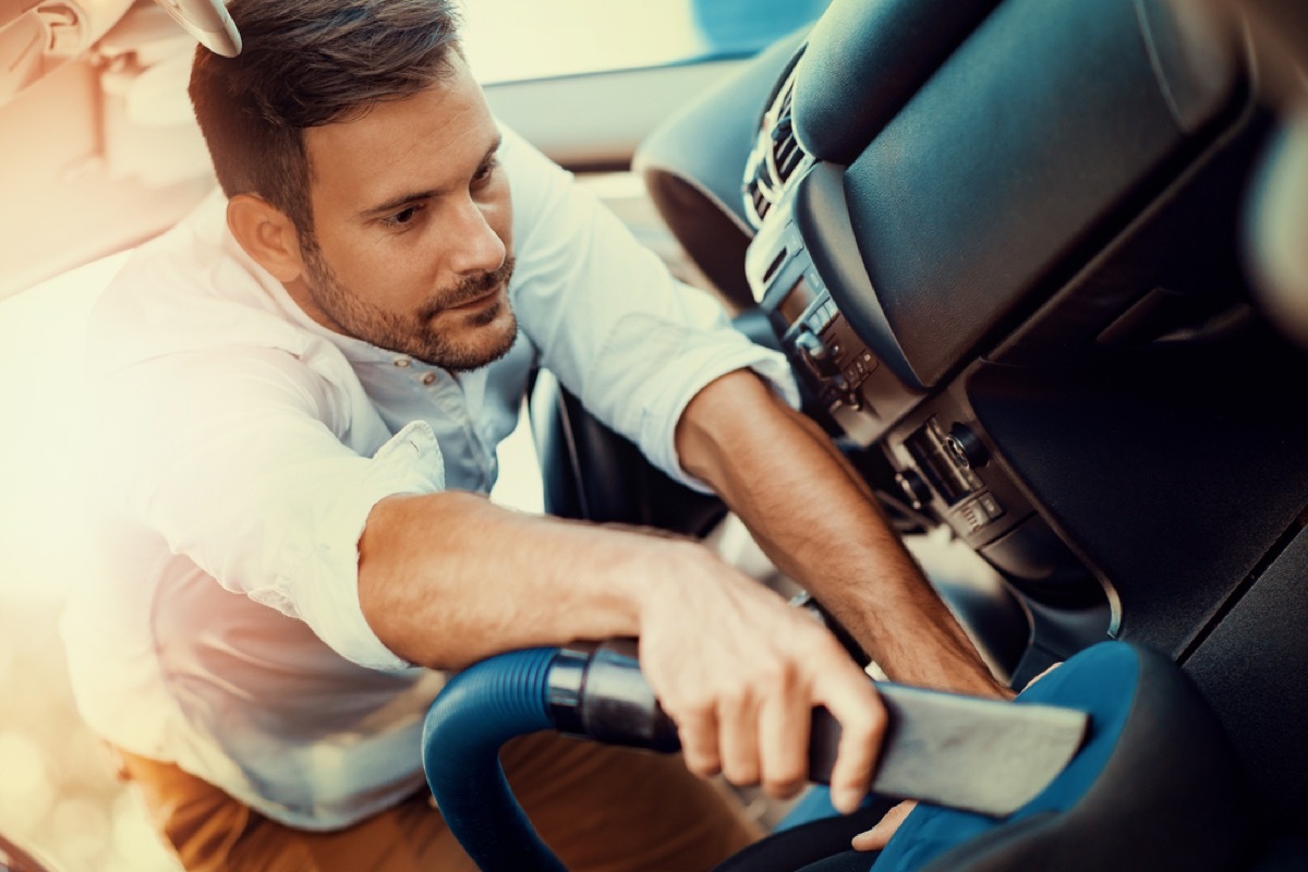 man vacuuming car with precision attachment, easy home tips