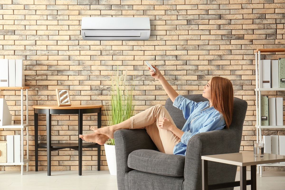 woman adjusting air conditioner, bad home renovations