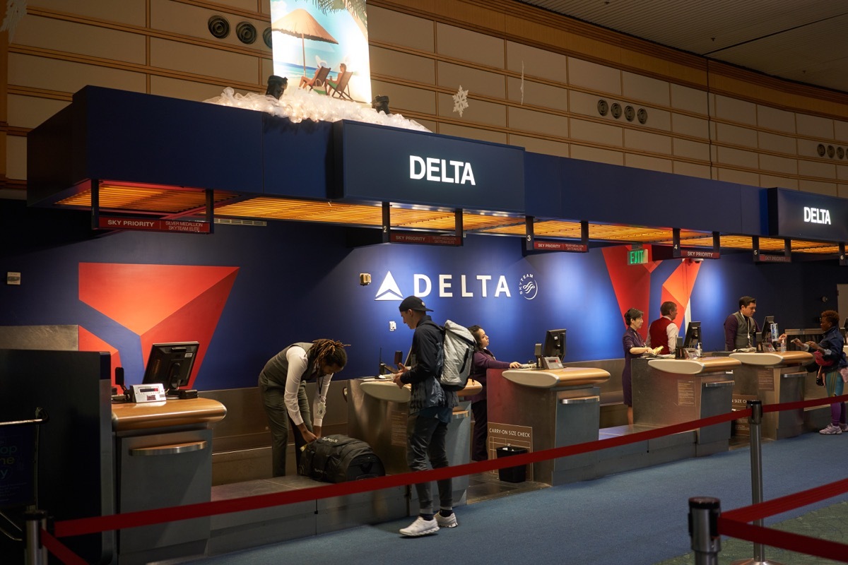 Portland, Oregon, USA - Dec 4, 2019: A passenger checks his baggage at the Delta Air Lines check-in desk in Portland International Airport.