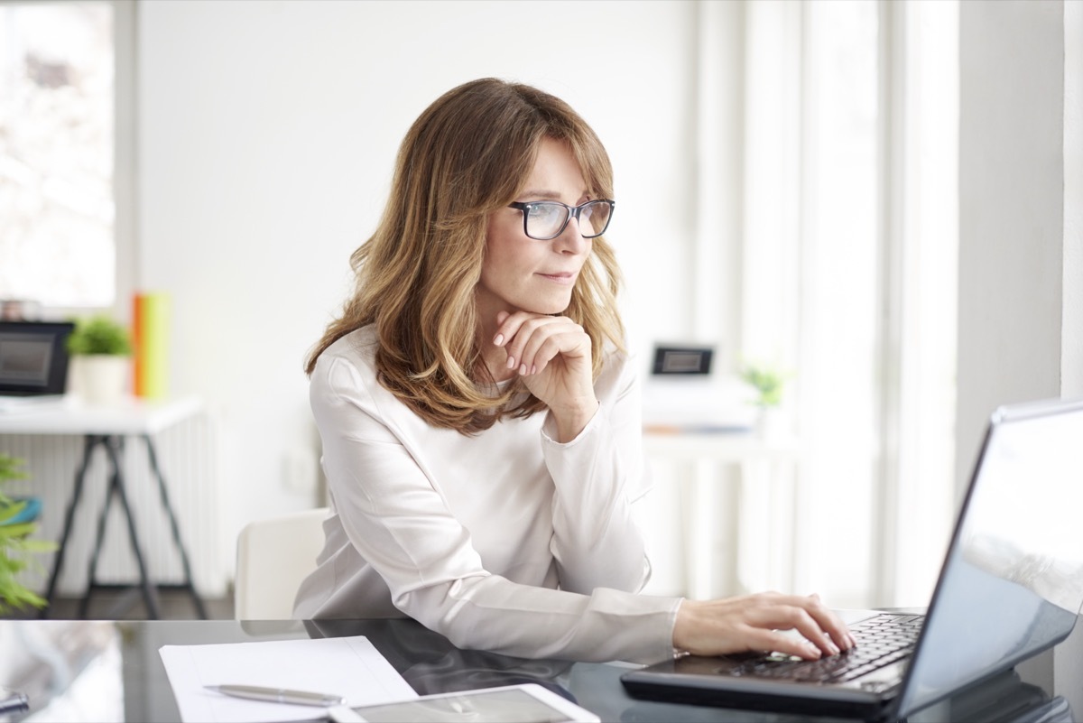 Mature businesswoman working on laptop in her workstation.