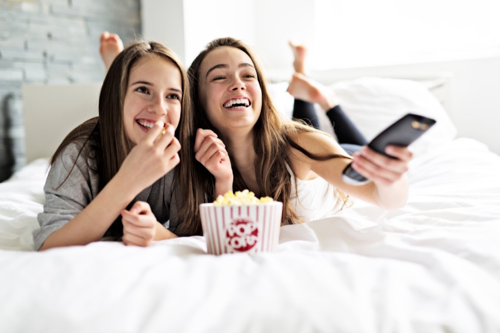 teens watching movie in bed