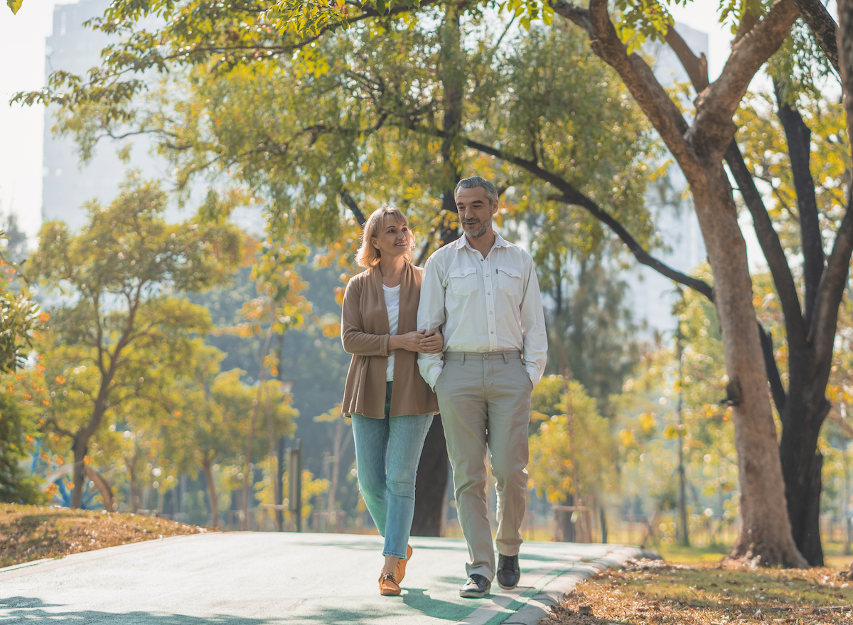 older-couple-walking-outside-in-park