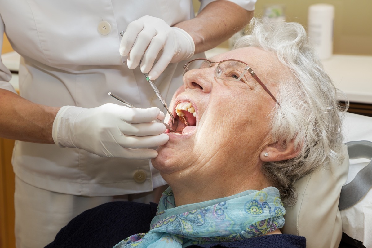 An Older Woman Getting Her Mouth Checked Out at the Dentist, subtle symptoms of serious disease