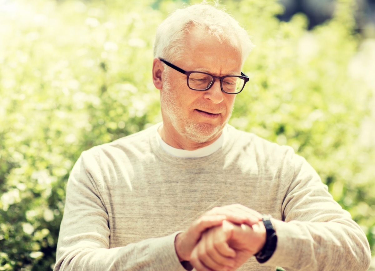 older white man looking at watch