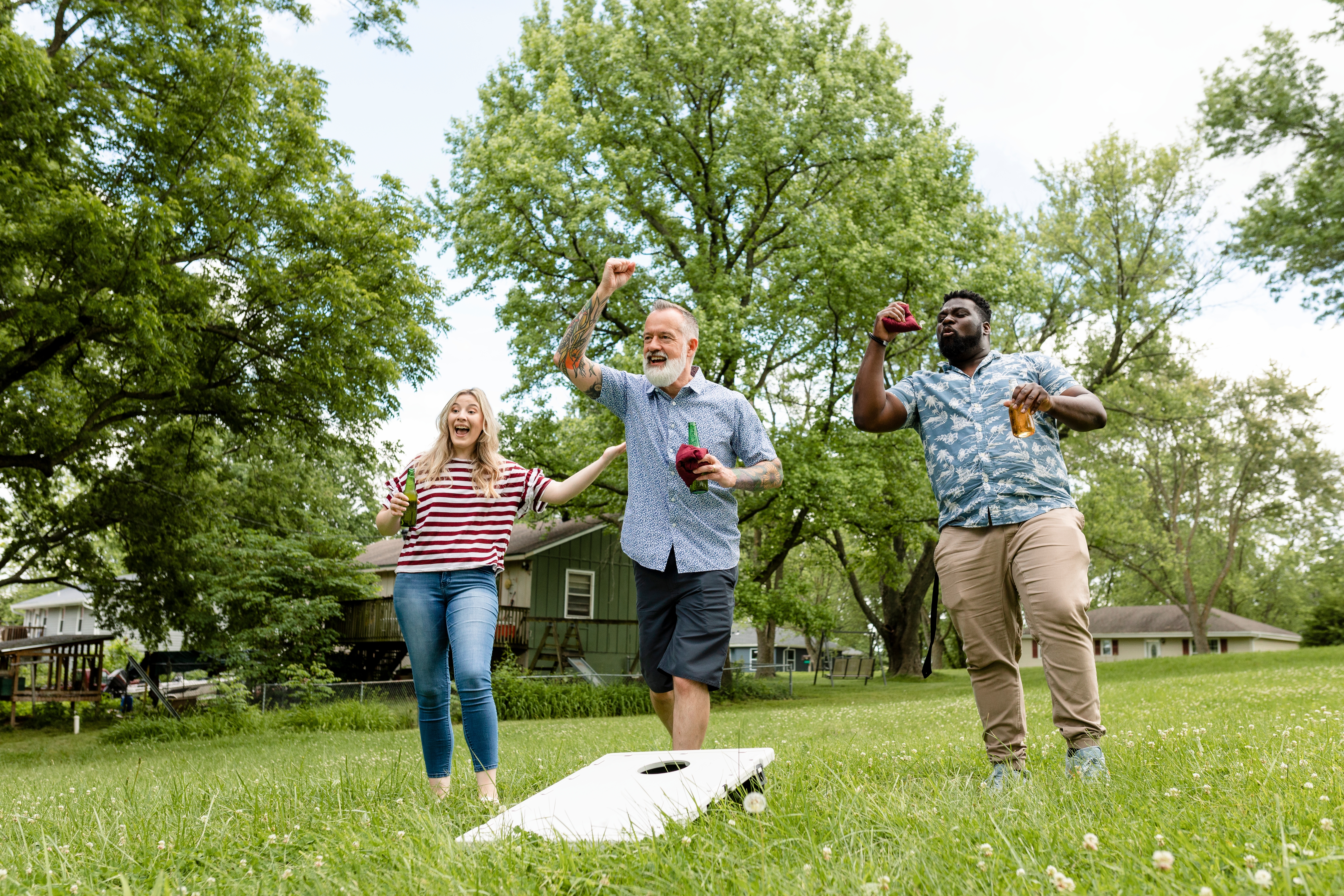 group of friends playing cornhole outside