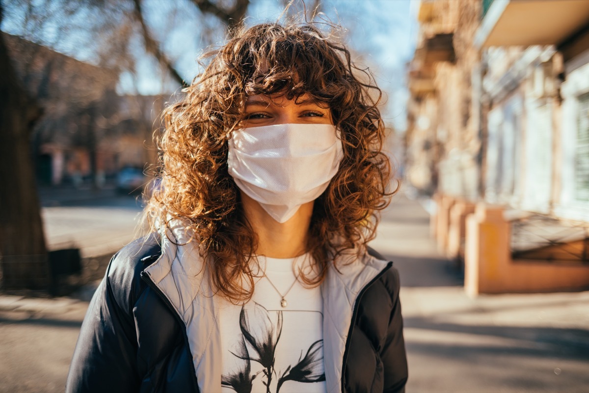 Young woman with mask on outdoors