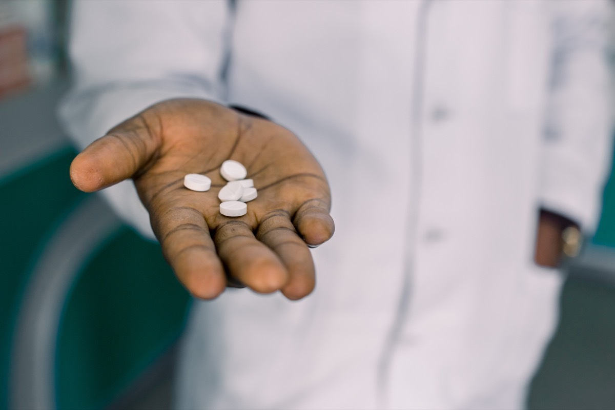 Man holding pills, medication, or vitamins