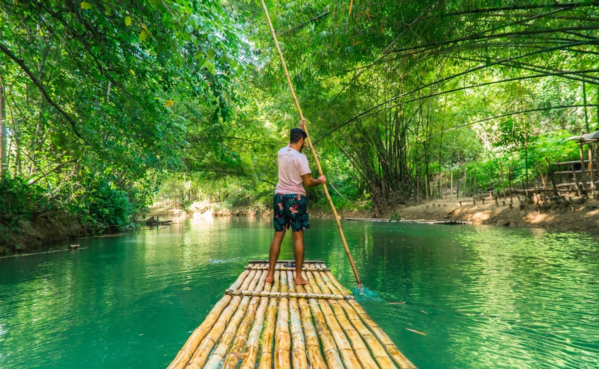 Man stand up paddling on a raft down a river