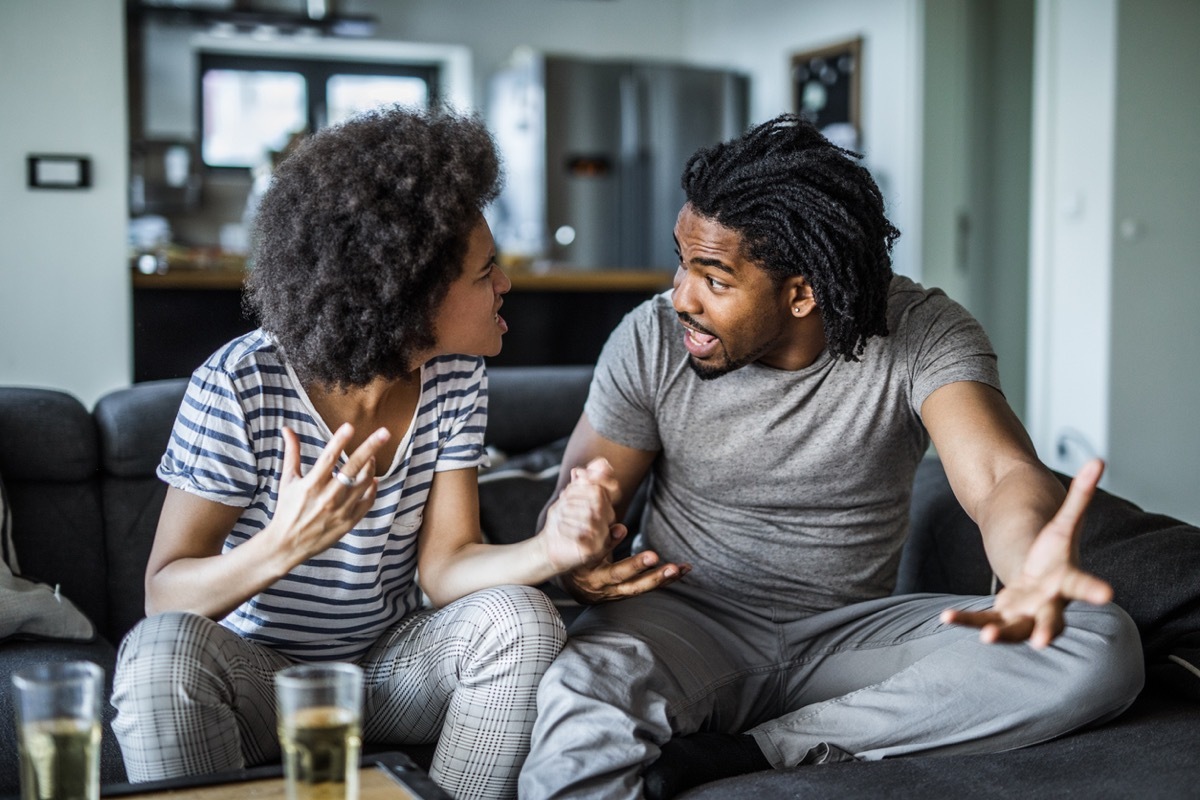 young black woman and young black man arguing with each other on the couch