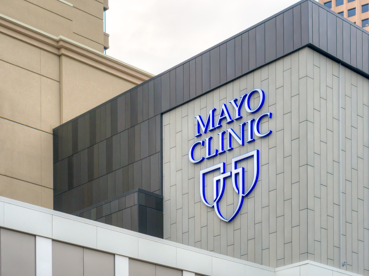 Mayo Clinic entrance and sign on side of white building, state fact about Minnesota