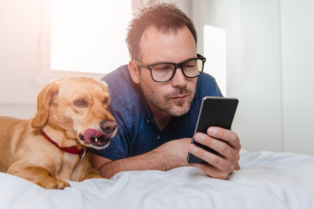 Man laying on his bed with his dog