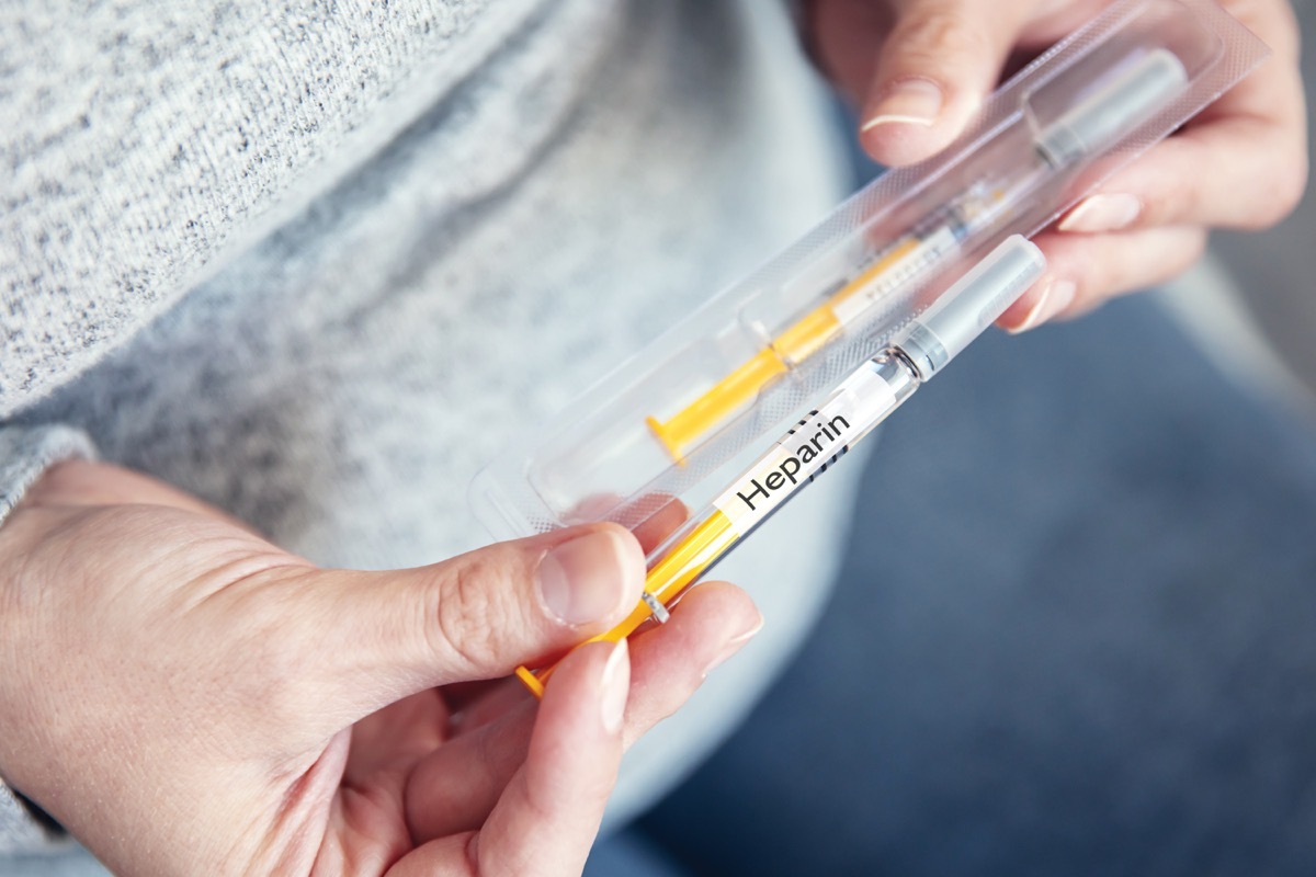 a patient is holding a heparin syringe