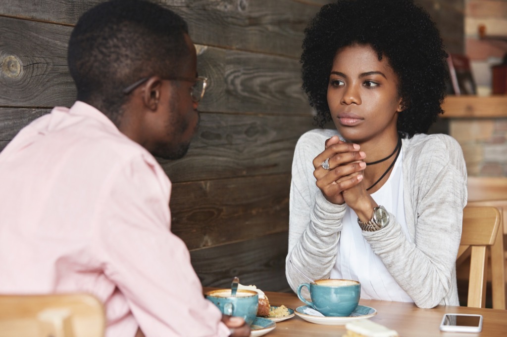 Man and woman on a date in a coffee shop looking bored