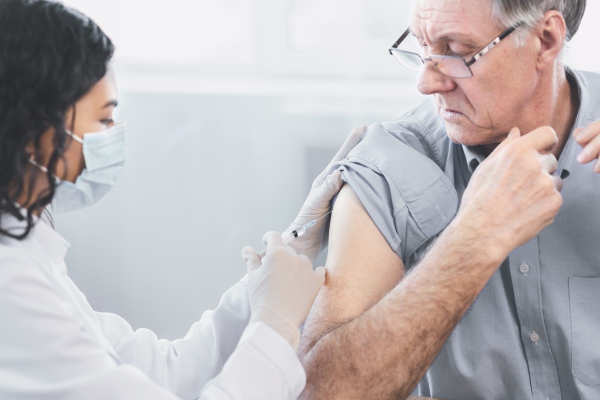 Closeup portrait nurse doing injection to senior man