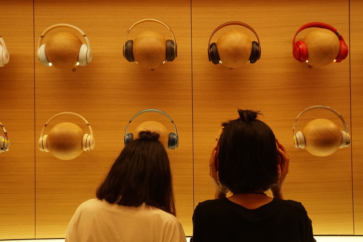 Girls trying on headphones at Apple store