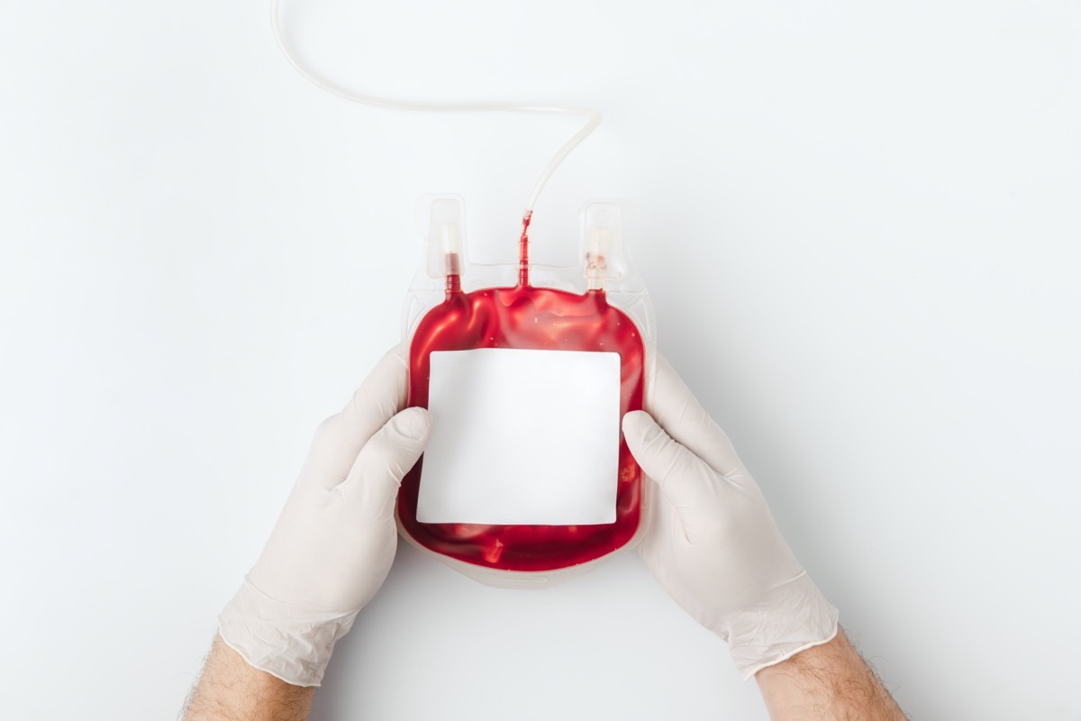 top view of hands in gloves holding blood for transfusion isolated on white background