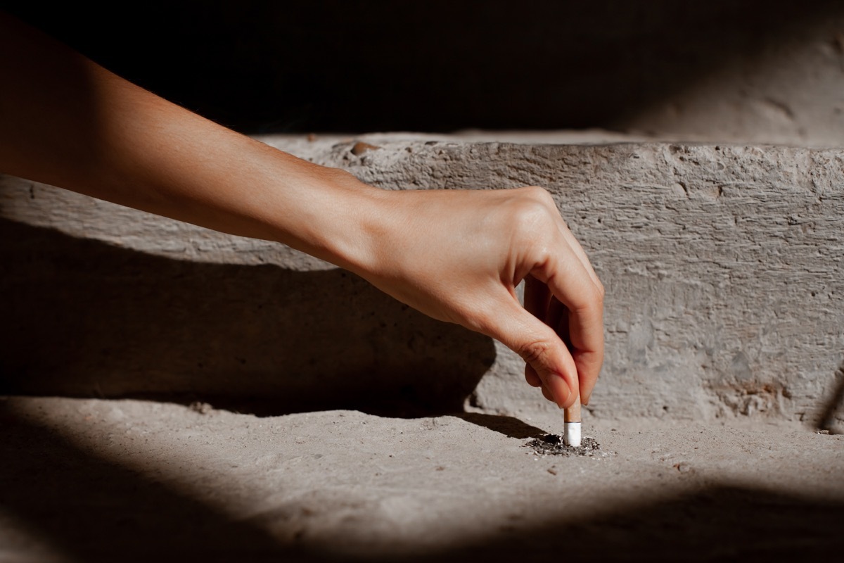 Person putting cigarette out