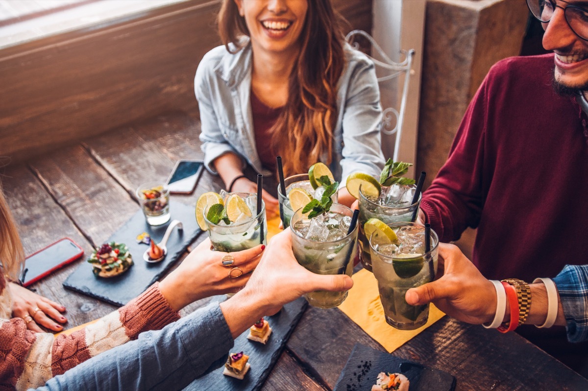 people holding up mojito, mojito in a clear glass