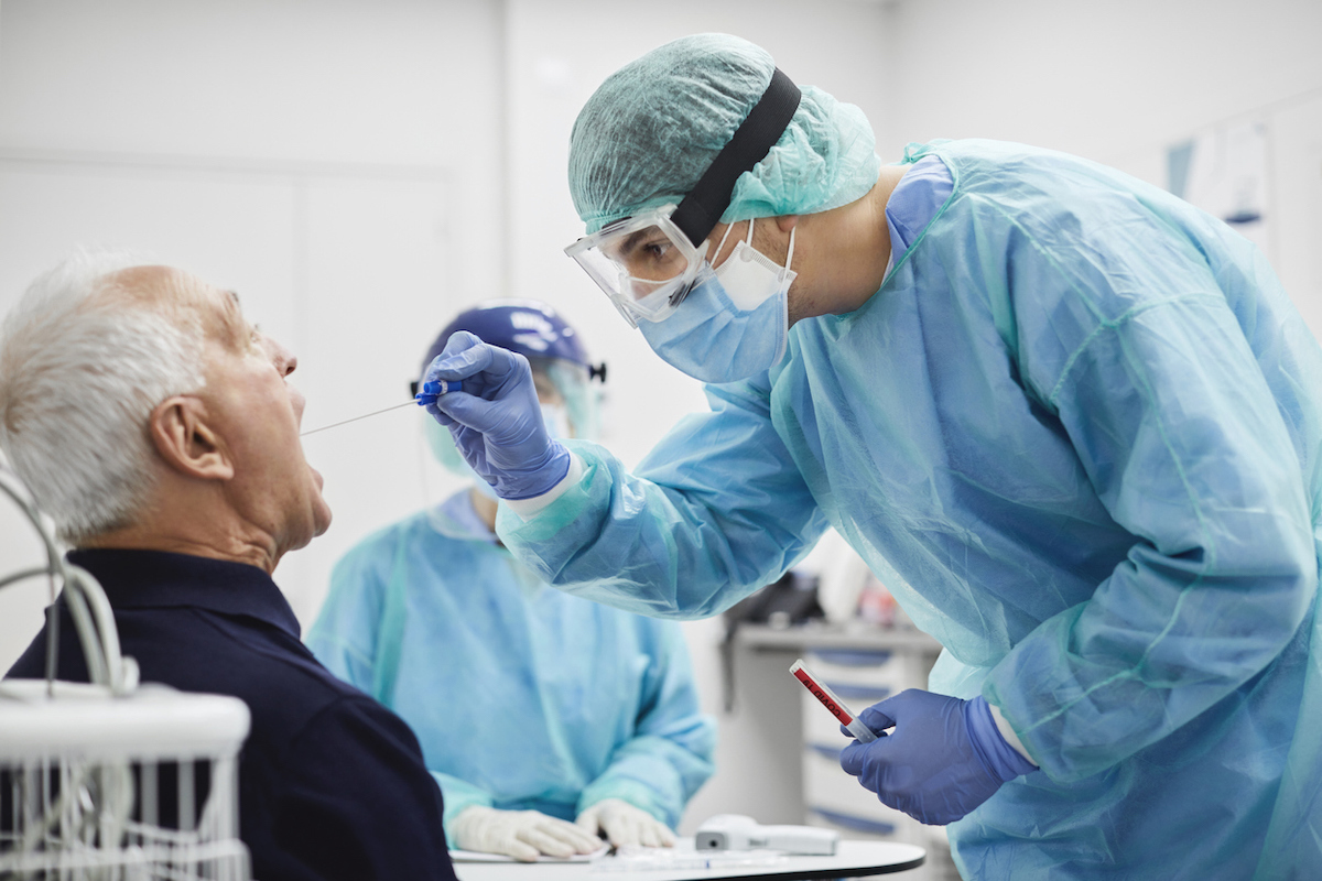 Doctor taking throat swab test from male patient