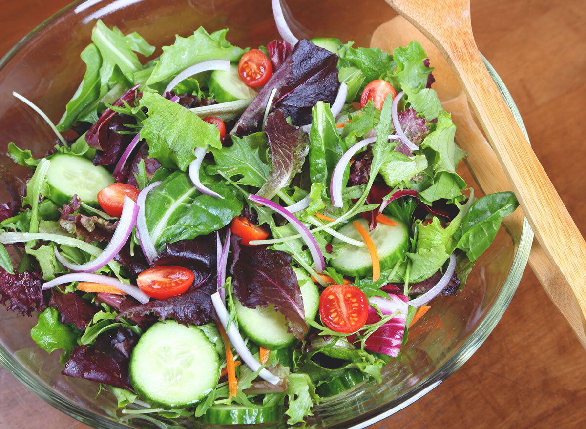 mixed green salad in glass bowl no dressing