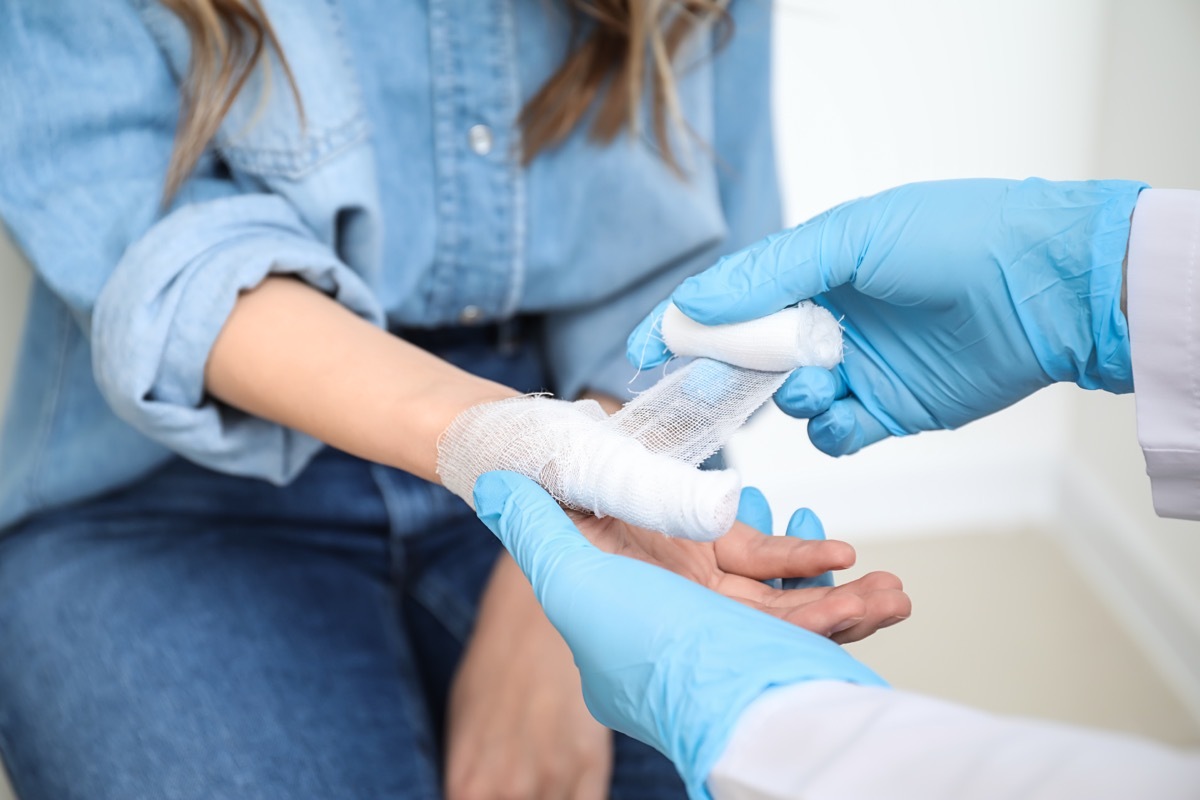 doctor bandaging woman's fingers