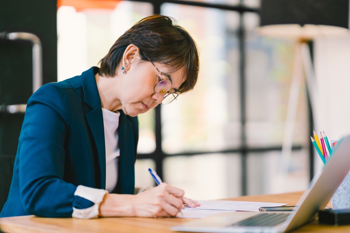 middle aged asian woman working at home at wfh office desk