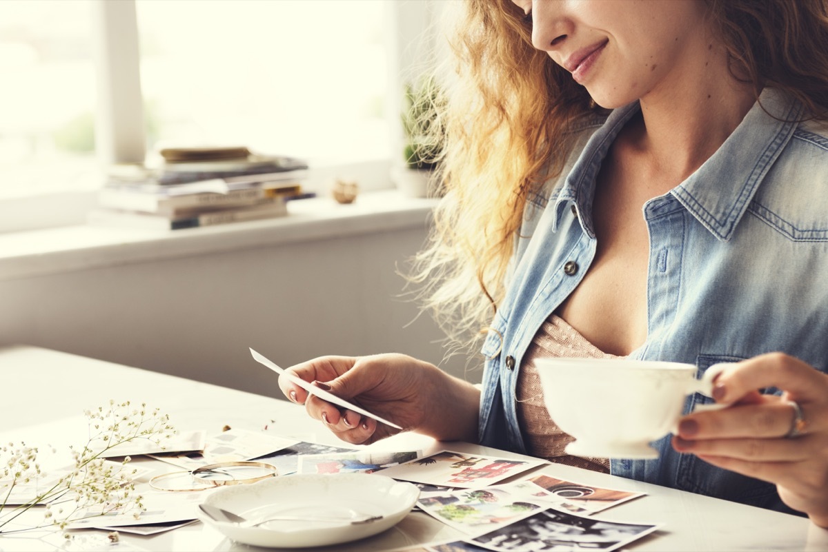 woman reminiscing with old photographs at home