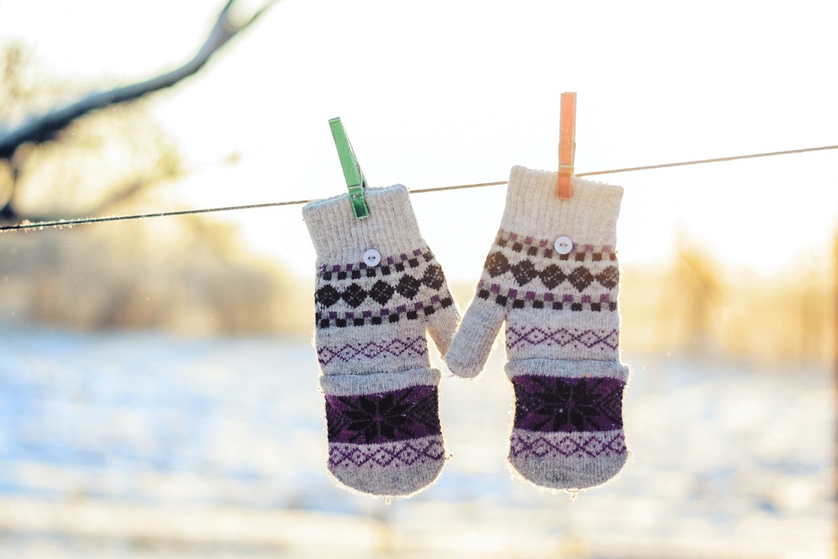 Grey wool gloves with a pattern hanging on a leash