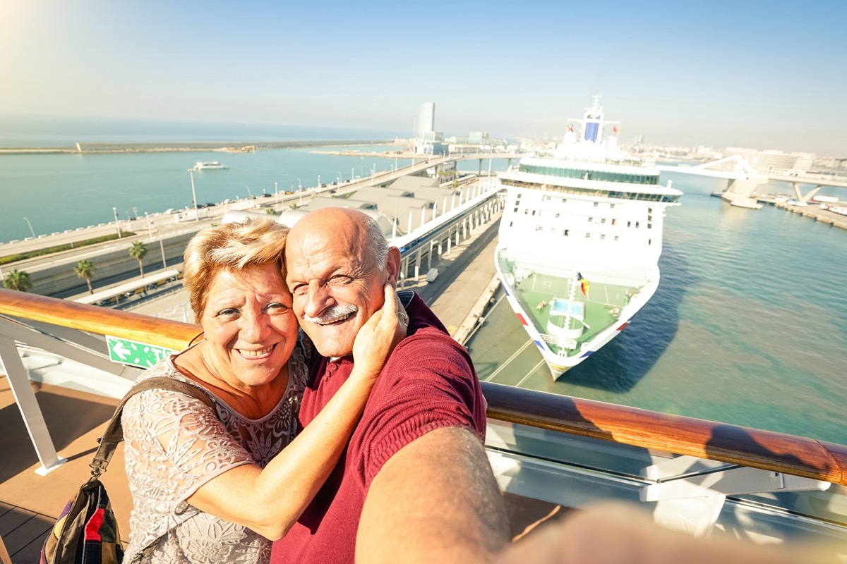 Senior happy couple taking selfie on ship on harbor background