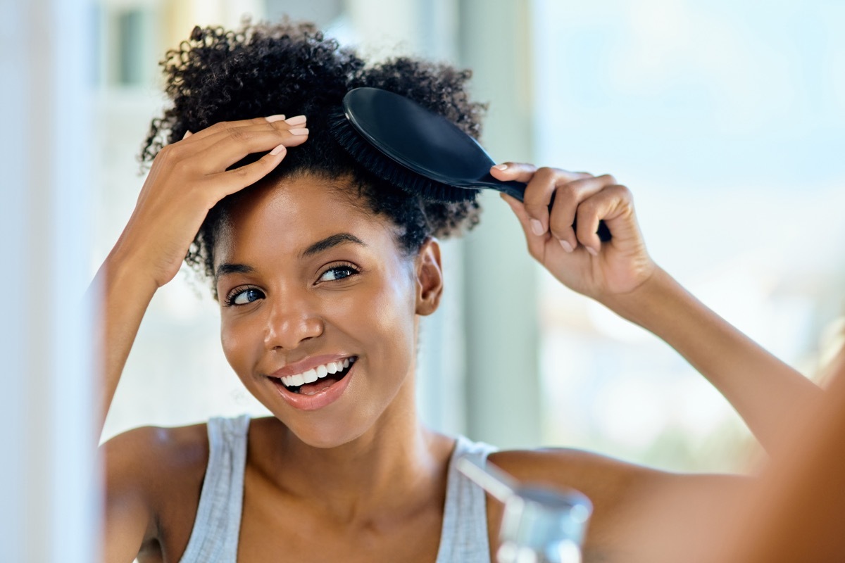 smiling-woman-brushing-her-hair