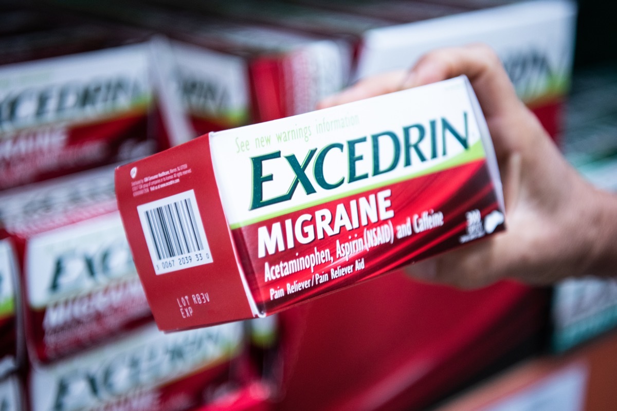 Los Angeles, CA/USA 7-1-2019 Shoppers hand holding a box of Excedrin brand genuine Migraine Acetaminophen tablets in supermarket aisle