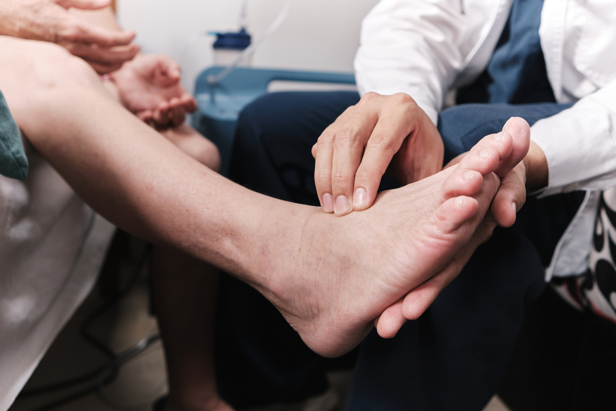 Medical doctor taking patient's pulse in the foot.