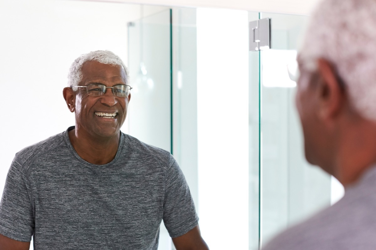 smiing senior man looking at reflection