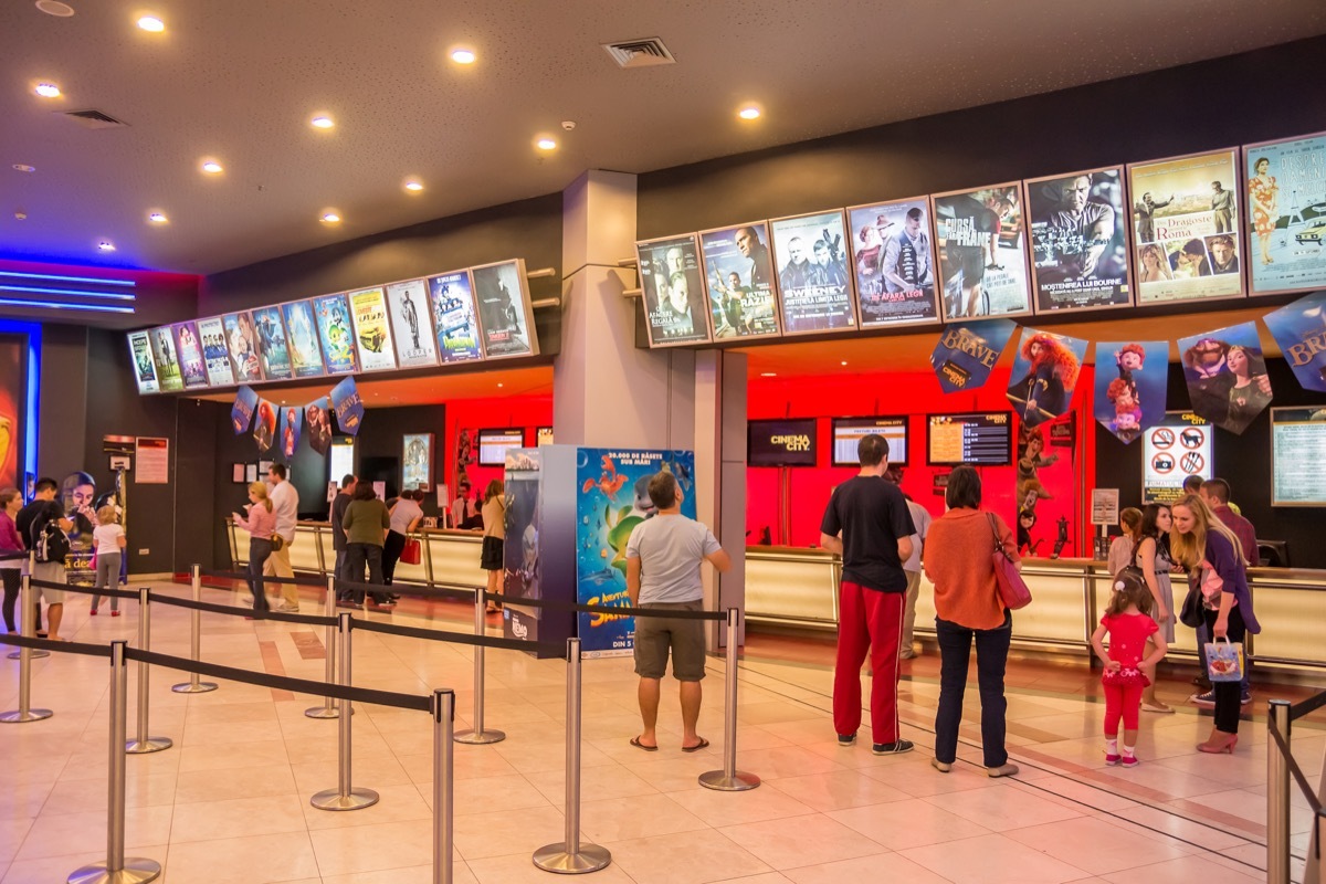 people buying tickets at the movie theater