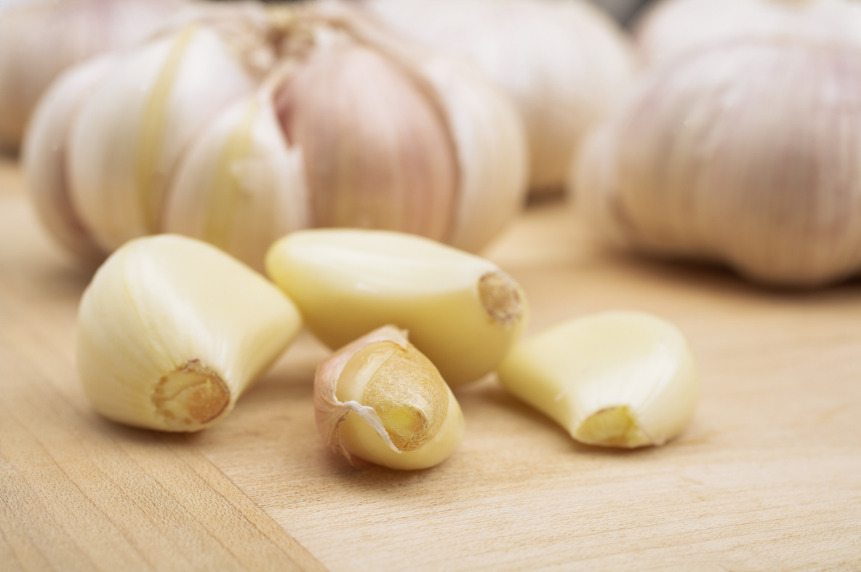 Garlic cloves on a wooden board. 