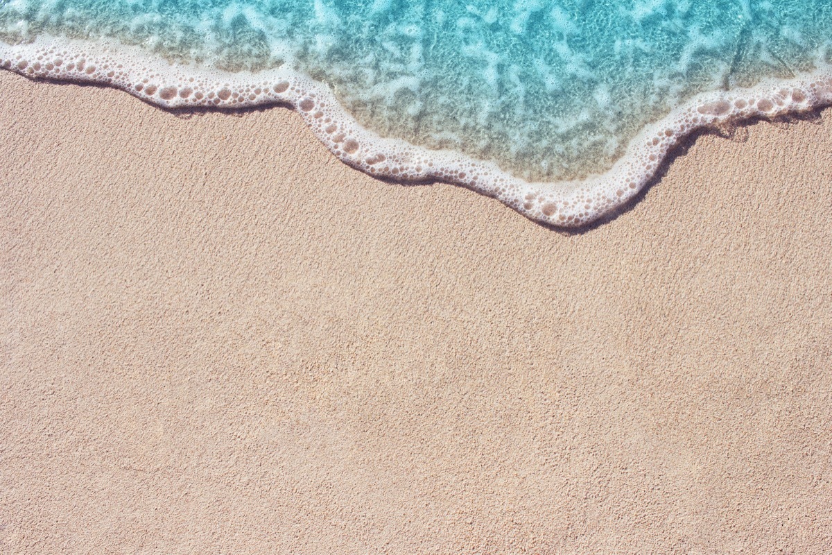 Soft wave of blue ocean on sandy beach