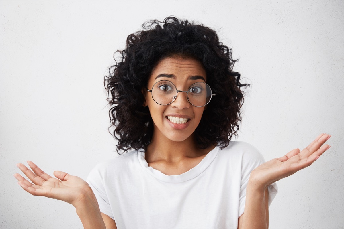 female wearing white T-shirt, feeling guilty, confused, making helpless gesture with hands, having Oops expression on her face {Groundhog Day is Weird}