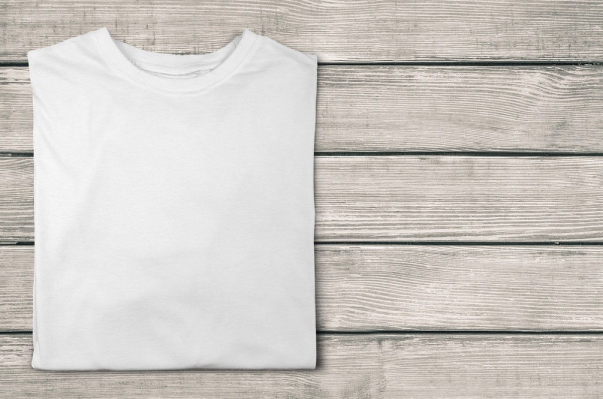 white t-shirt folded on wood background