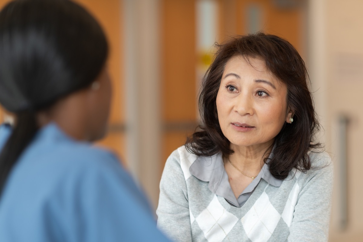 nurse is teaching her adult patient how to correctly use an asthma inhaler.