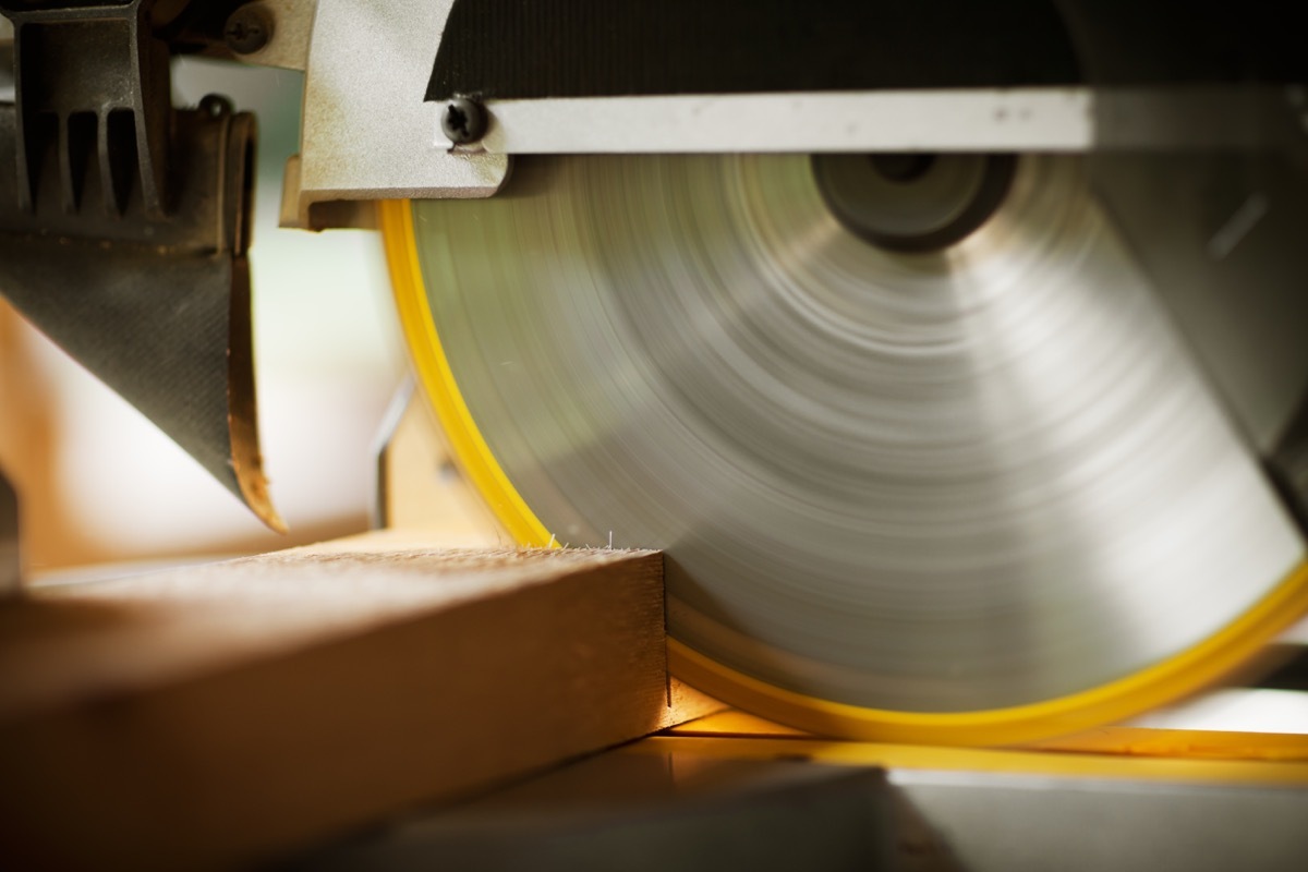 Closeup of a circular saw cutting through construction timber. Horizontal shot.