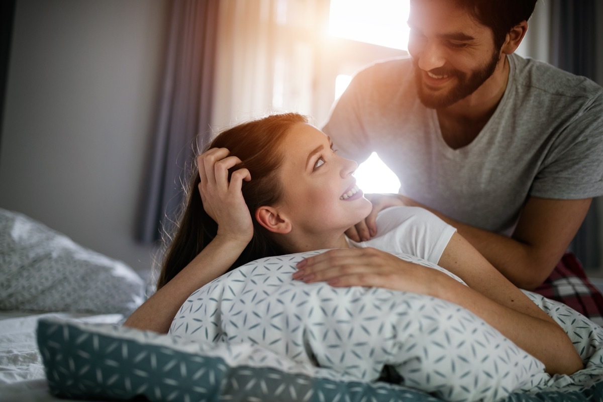 boyfriend giving his girlfriend a back rub in the bed