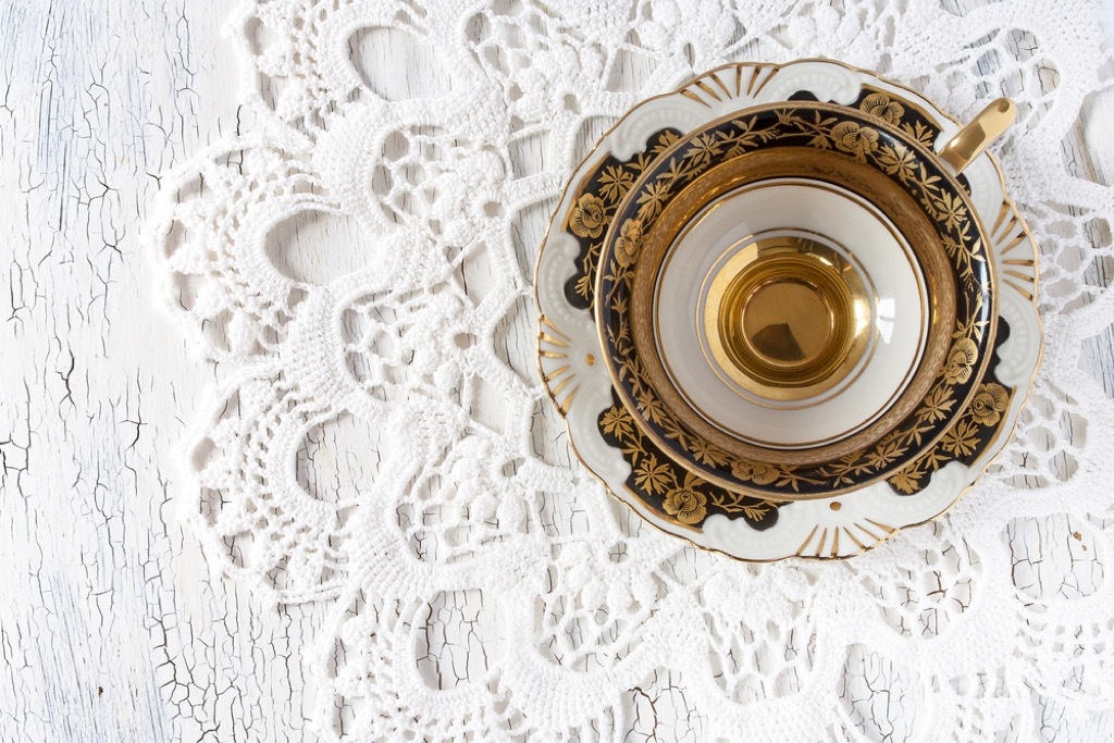 tea cup on white lace doily