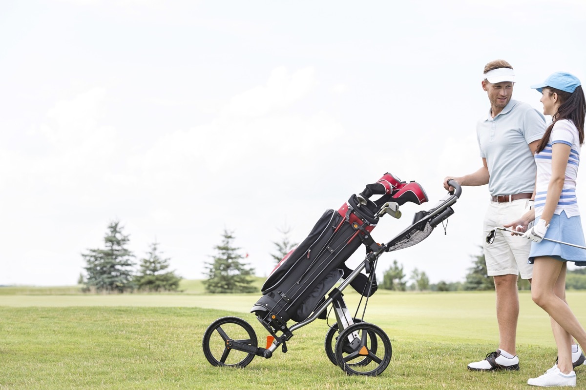 male and female golfers using a pushcart 