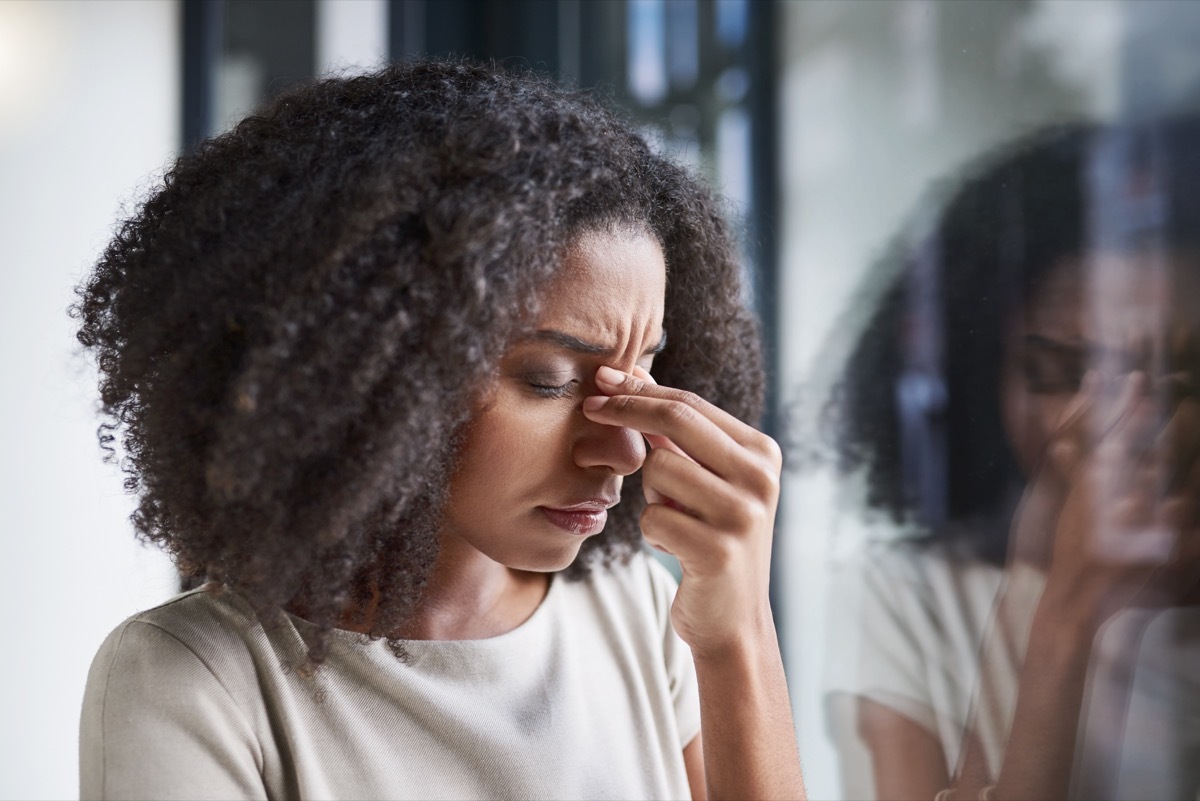 Cropped shot of an attractive young businesswoman suffering with a headache while standing in her office