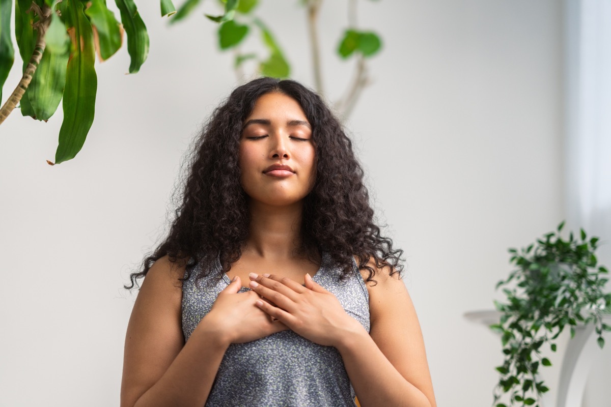 woman is doing breathing exercise at home.