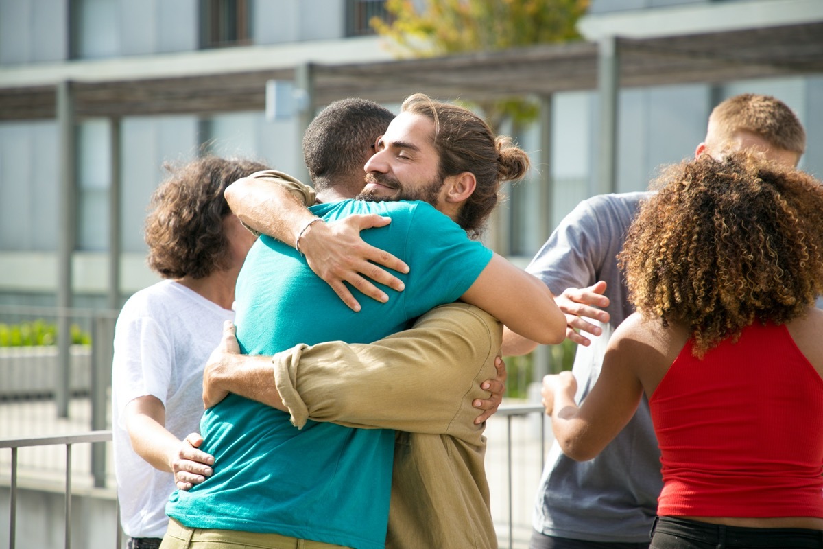 Happy guys in casual hugging each other.