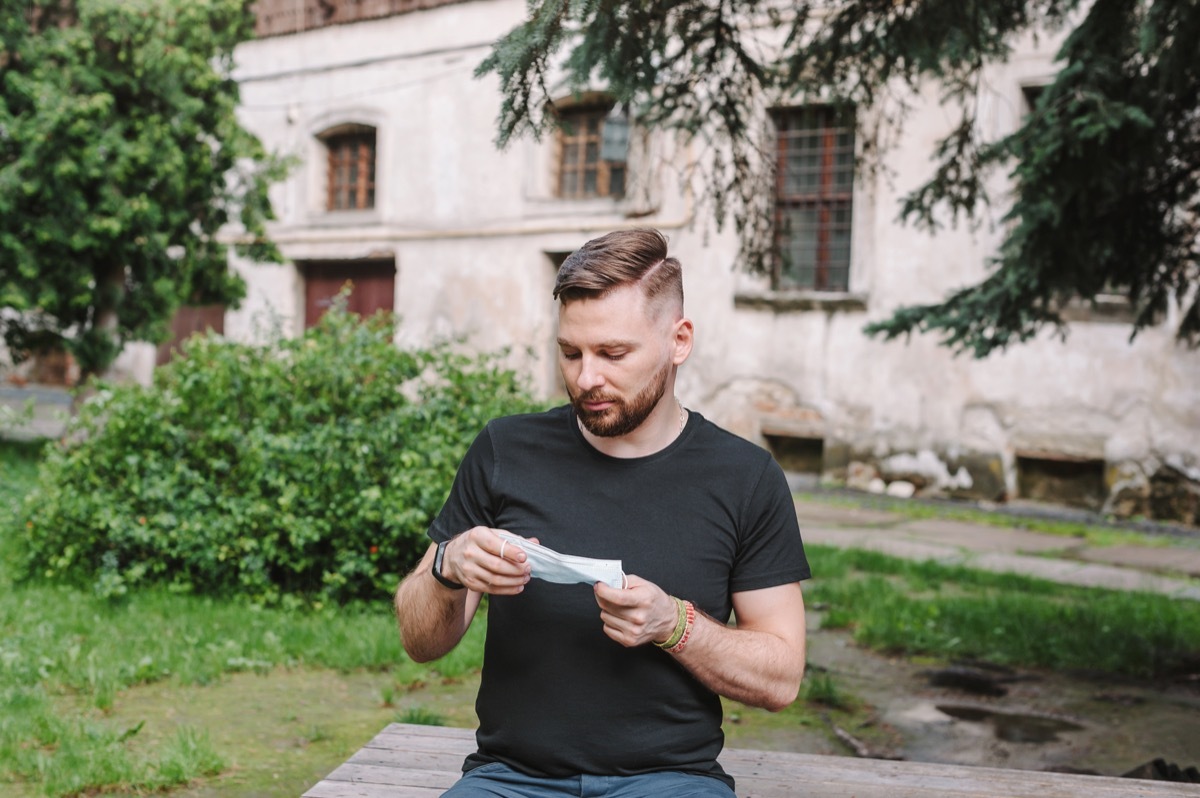 Man not wearing mask just holding it