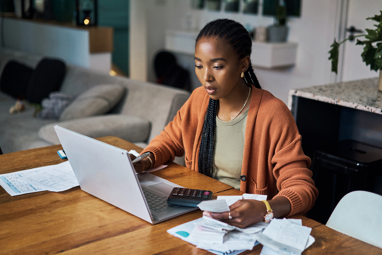 A woman sitting at a laptop while budgeting or filing taxes