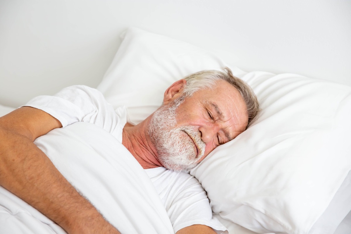 older white man asleep in bed