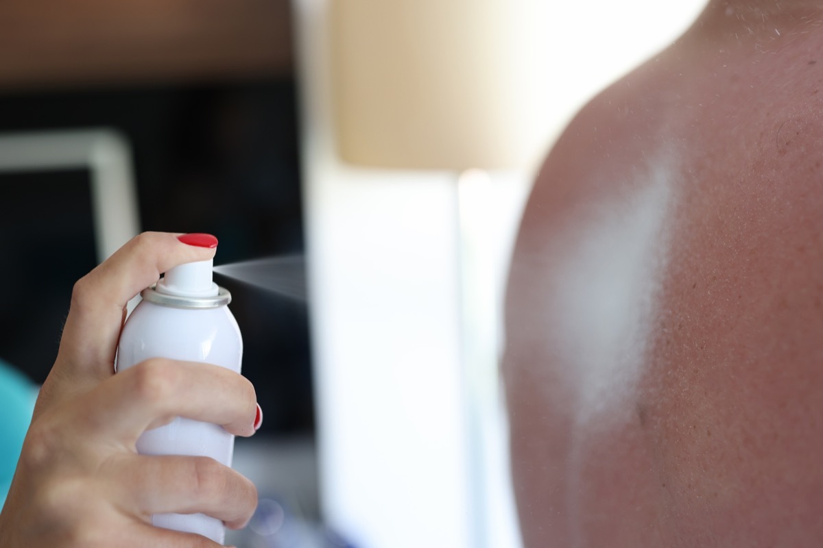 person applying sunscreen to another person's back